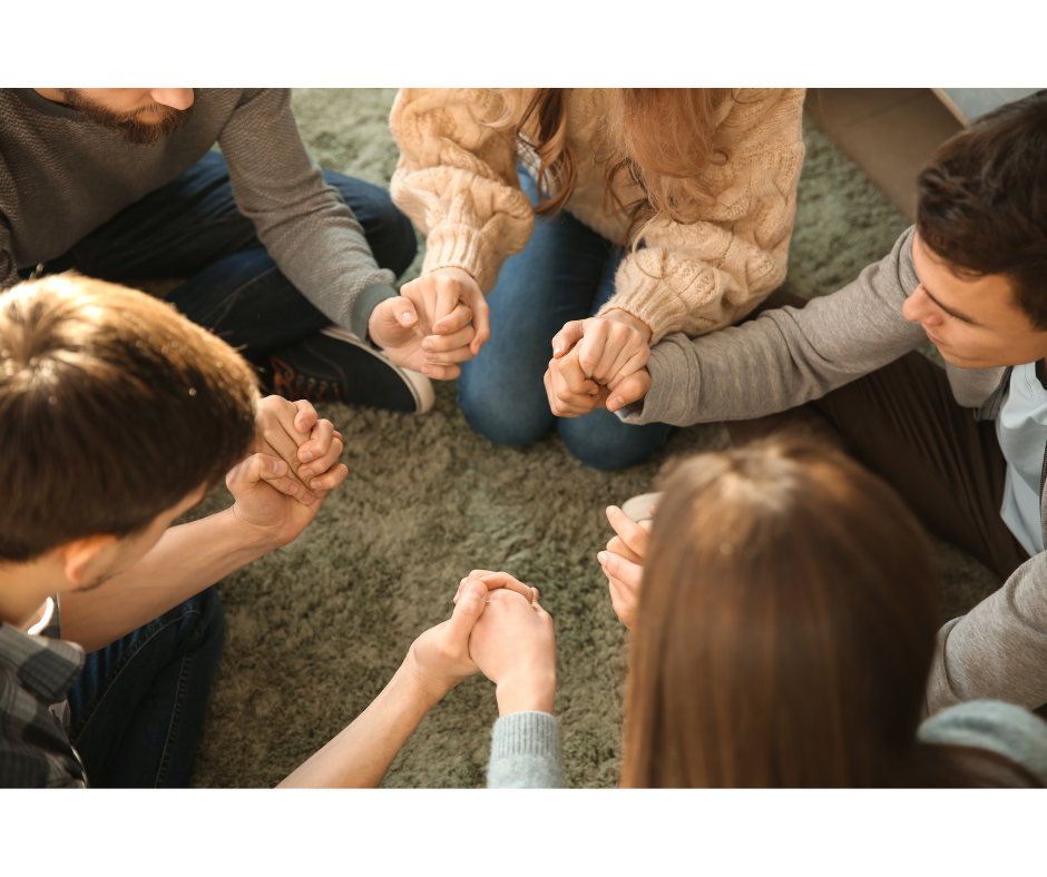 Top view of hand holding teal ribbon on dark background with copy space. Cervical and ovarian cancer, sexual assault, pcos, ptsd, anxiety disorder, agoraphobia and scleroderma awareness concept.