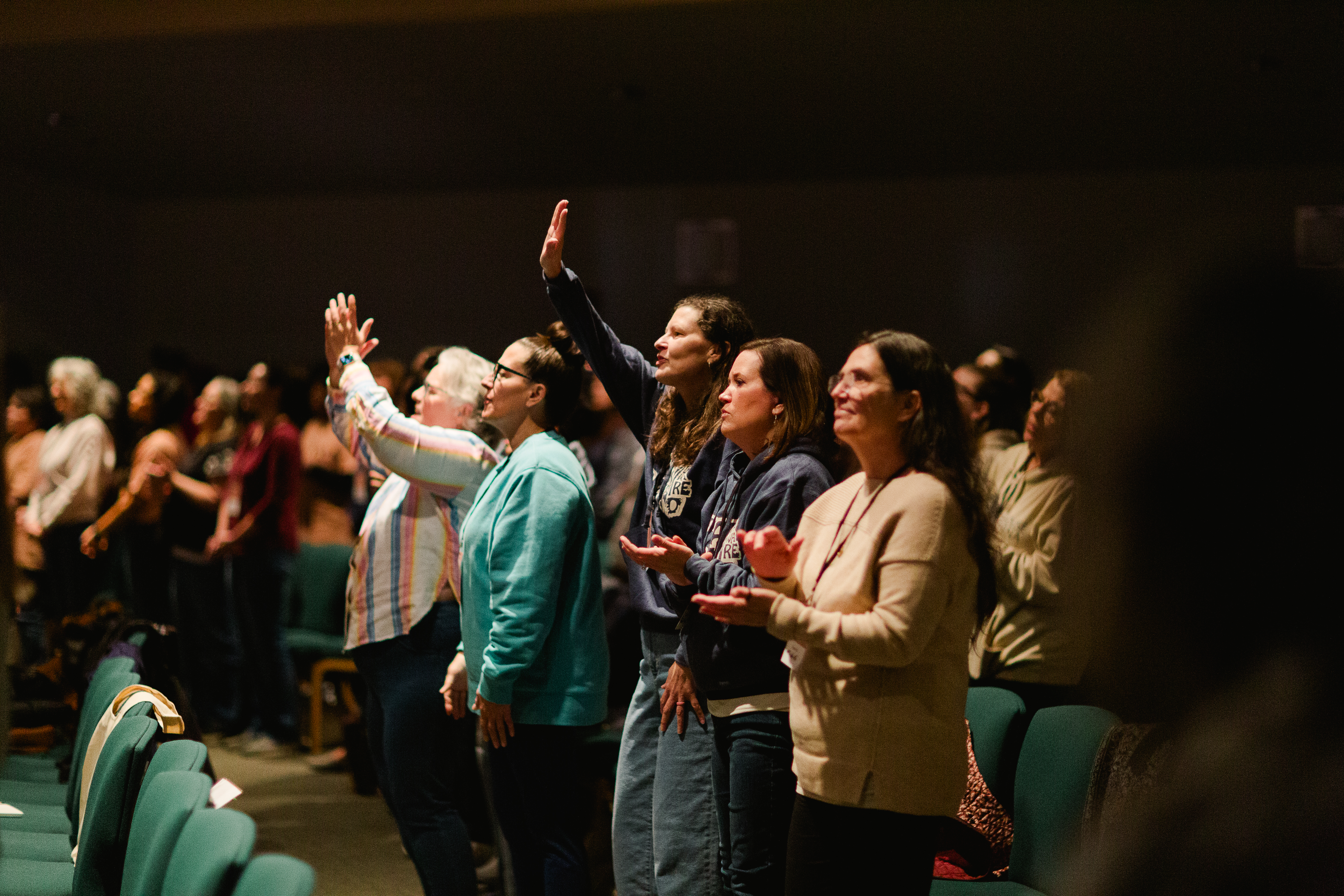 Top view of hand holding teal ribbon on dark background with copy space. Cervical and ovarian cancer, sexual assault, pcos, ptsd, anxiety disorder, agoraphobia and scleroderma awareness concept.