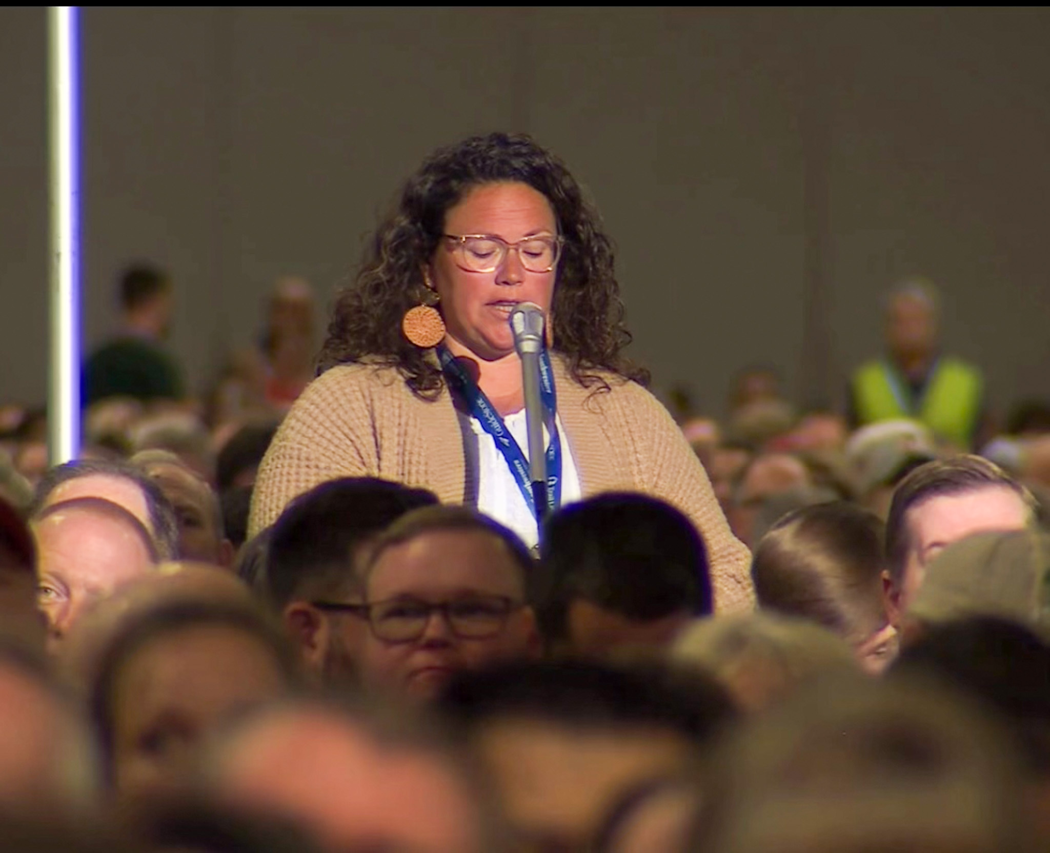 Top view of hand holding teal ribbon on dark background with copy space. Cervical and ovarian cancer, sexual assault, pcos, ptsd, anxiety disorder, agoraphobia and scleroderma awareness concept.