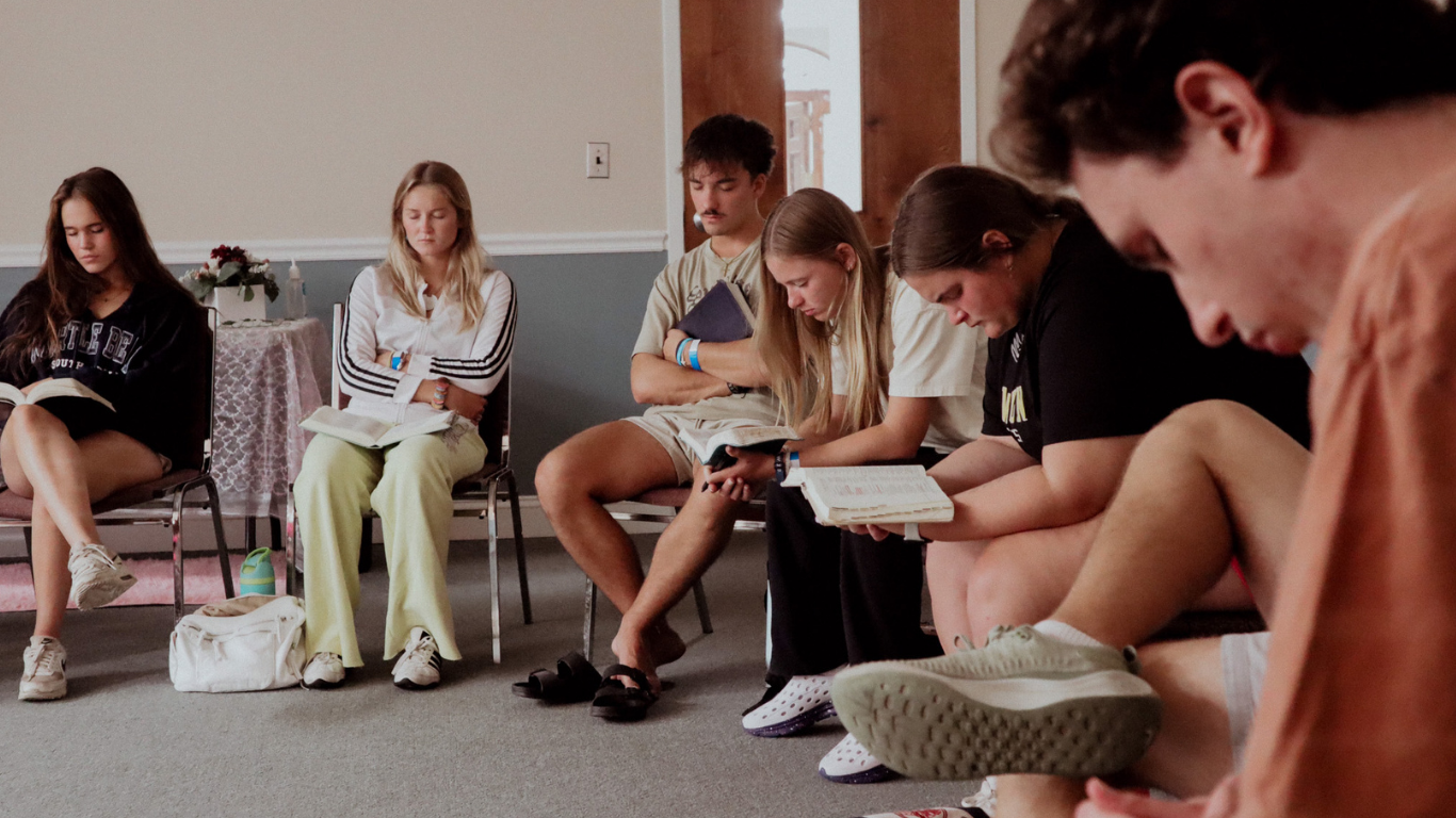 Top view of hand holding teal ribbon on dark background with copy space. Cervical and ovarian cancer, sexual assault, pcos, ptsd, anxiety disorder, agoraphobia and scleroderma awareness concept.
