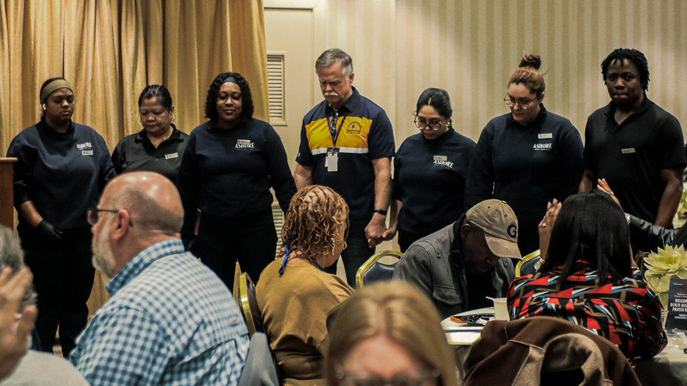 Top view of hand holding teal ribbon on dark background with copy space. Cervical and ovarian cancer, sexual assault, pcos, ptsd, anxiety disorder, agoraphobia and scleroderma awareness concept.