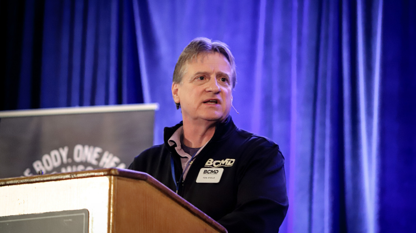 Top view of hand holding teal ribbon on dark background with copy space. Cervical and ovarian cancer, sexual assault, pcos, ptsd, anxiety disorder, agoraphobia and scleroderma awareness concept.