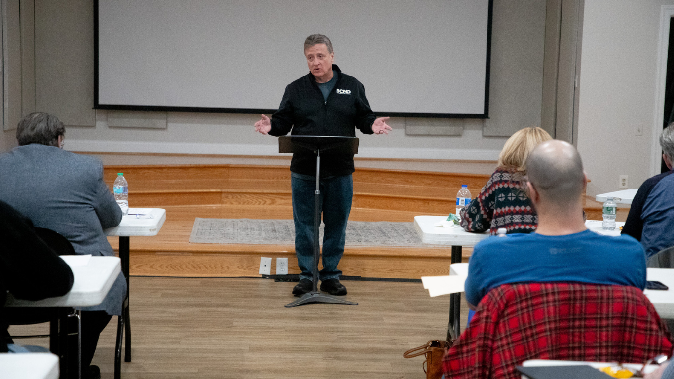 Top view of hand holding teal ribbon on dark background with copy space. Cervical and ovarian cancer, sexual assault, pcos, ptsd, anxiety disorder, agoraphobia and scleroderma awareness concept.