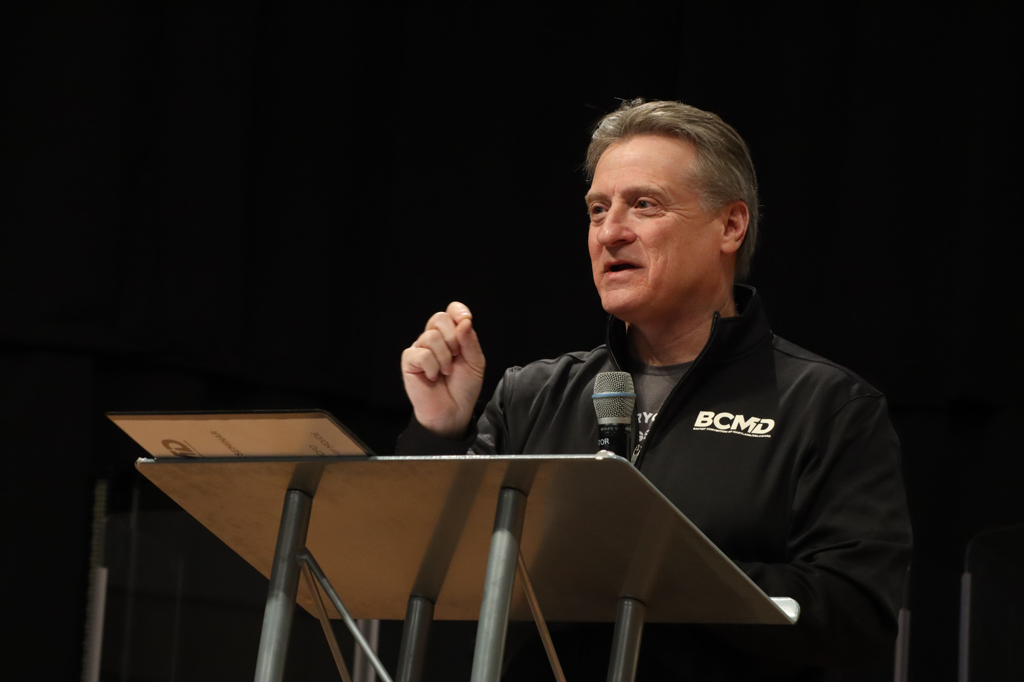 Top view of hand holding teal ribbon on dark background with copy space. Cervical and ovarian cancer, sexual assault, pcos, ptsd, anxiety disorder, agoraphobia and scleroderma awareness concept.