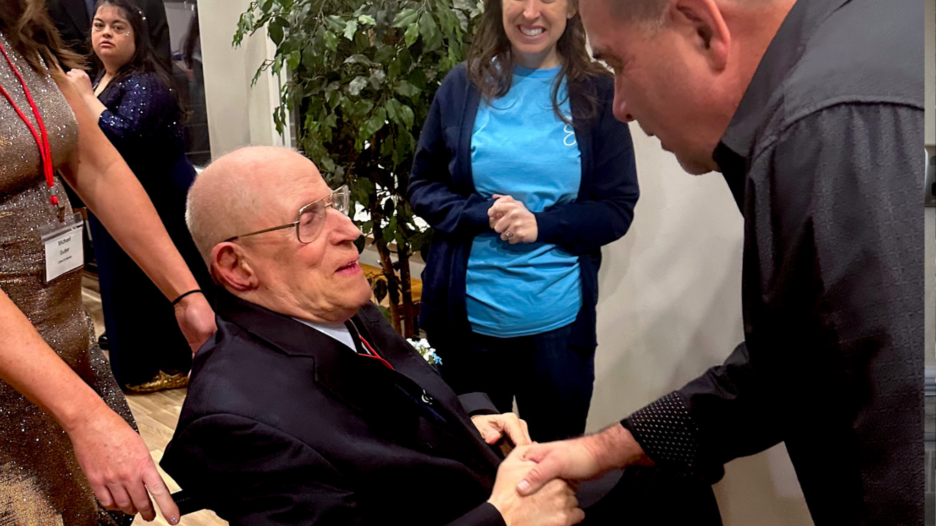 Top view of hand holding teal ribbon on dark background with copy space. Cervical and ovarian cancer, sexual assault, pcos, ptsd, anxiety disorder, agoraphobia and scleroderma awareness concept.