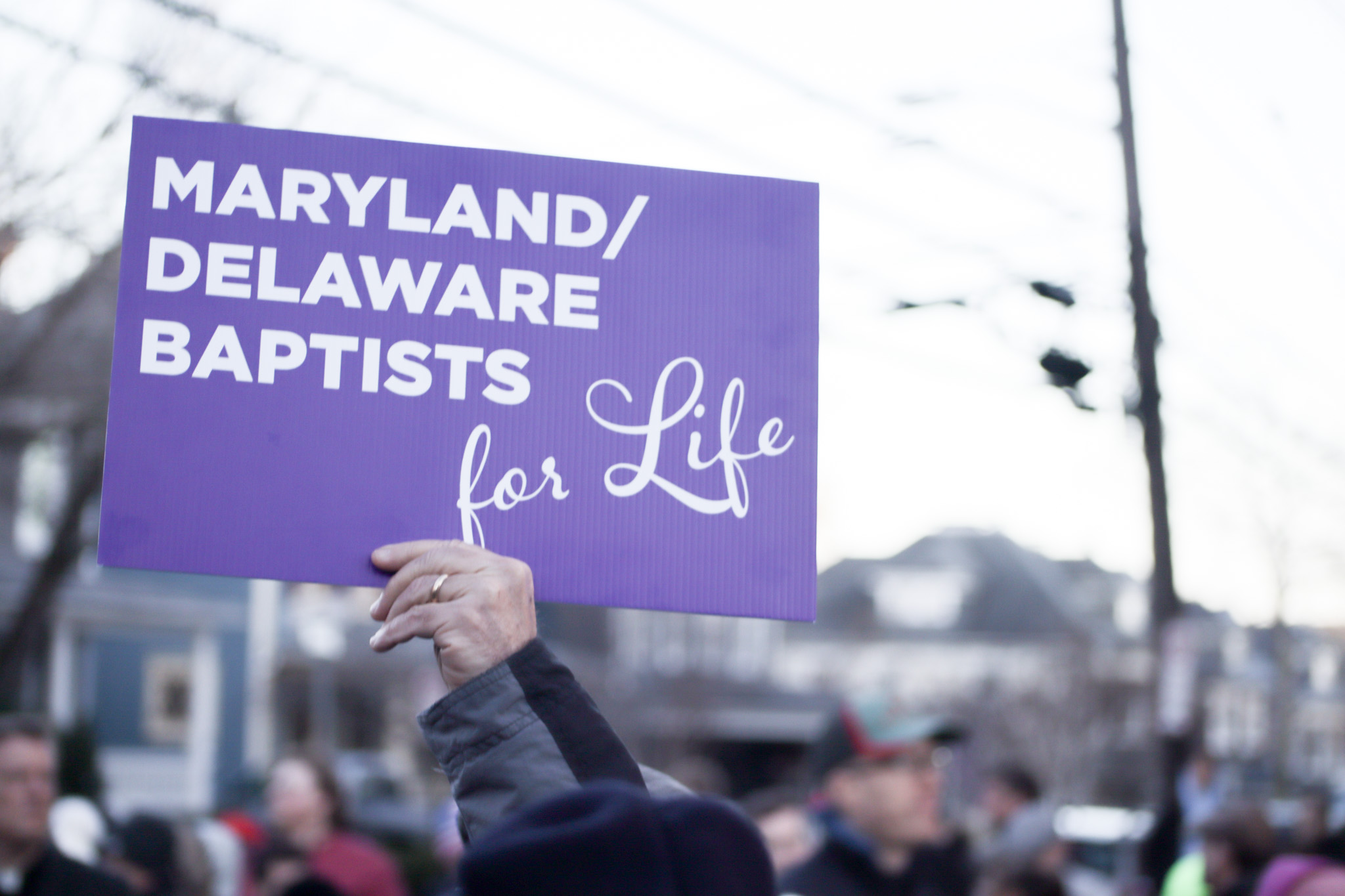Top view of hand holding teal ribbon on dark background with copy space. Cervical and ovarian cancer, sexual assault, pcos, ptsd, anxiety disorder, agoraphobia and scleroderma awareness concept.
