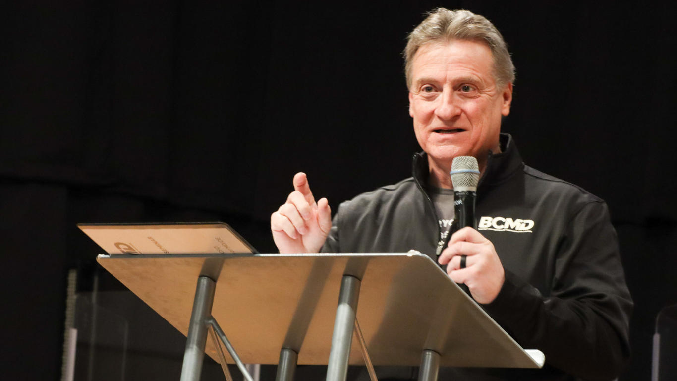 Top view of hand holding teal ribbon on dark background with copy space. Cervical and ovarian cancer, sexual assault, pcos, ptsd, anxiety disorder, agoraphobia and scleroderma awareness concept.