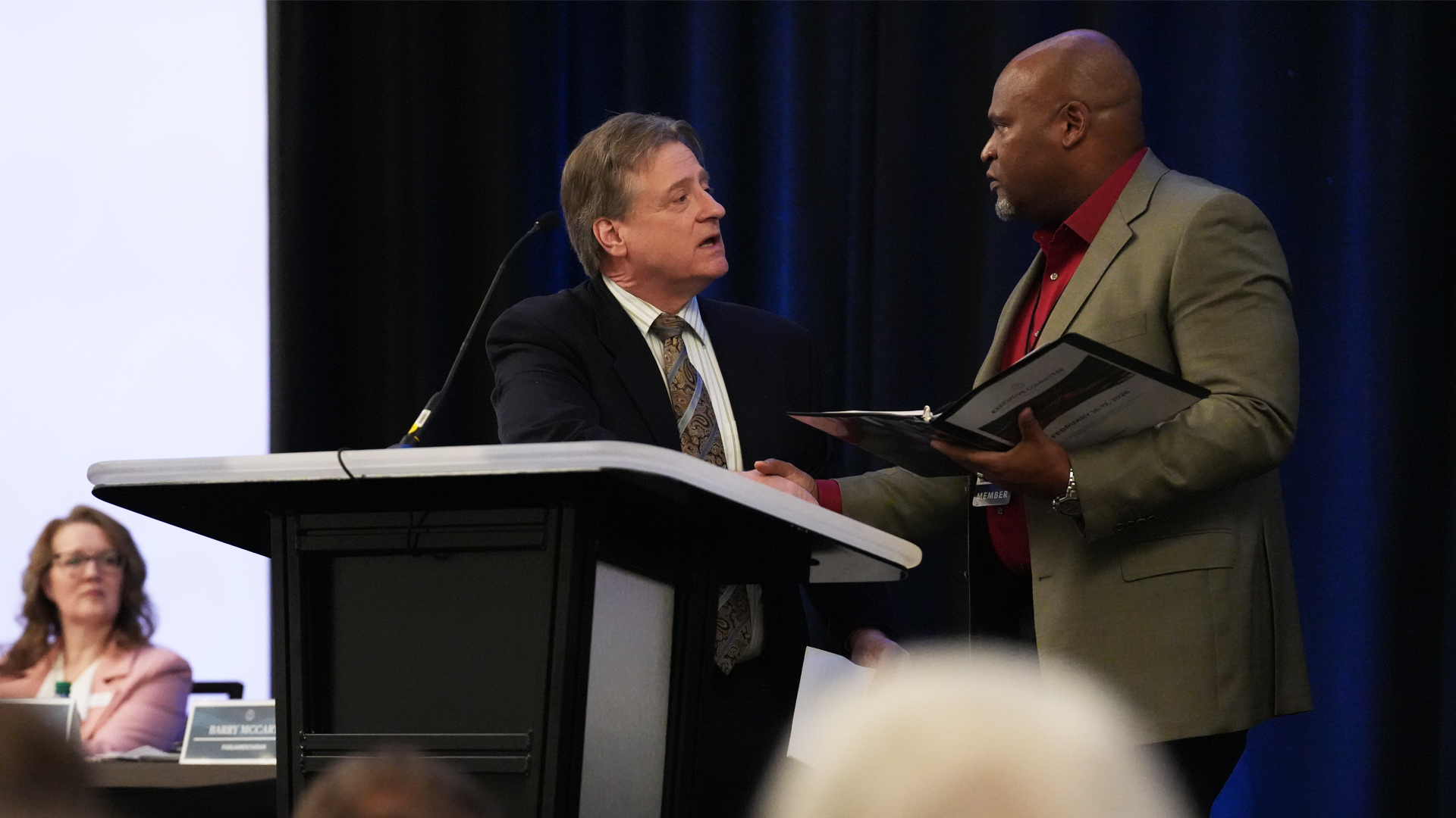 Top view of hand holding teal ribbon on dark background with copy space. Cervical and ovarian cancer, sexual assault, pcos, ptsd, anxiety disorder, agoraphobia and scleroderma awareness concept.