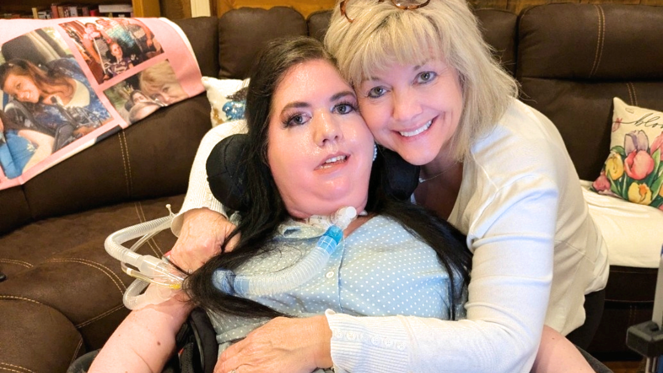 Top view of hand holding teal ribbon on dark background with copy space. Cervical and ovarian cancer, sexual assault, pcos, ptsd, anxiety disorder, agoraphobia and scleroderma awareness concept.