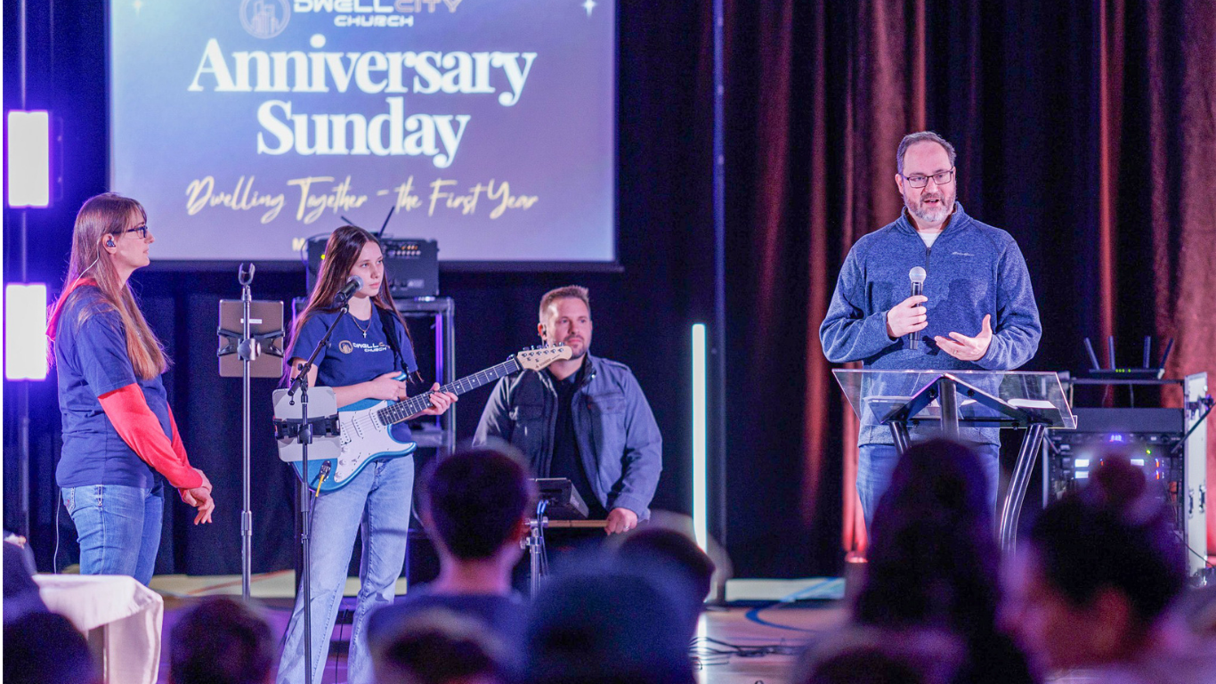 Top view of hand holding teal ribbon on dark background with copy space. Cervical and ovarian cancer, sexual assault, pcos, ptsd, anxiety disorder, agoraphobia and scleroderma awareness concept.