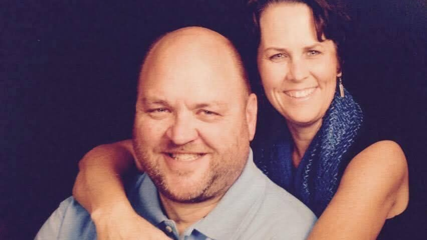 Top view of hand holding teal ribbon on dark background with copy space. Cervical and ovarian cancer, sexual assault, pcos, ptsd, anxiety disorder, agoraphobia and scleroderma awareness concept.