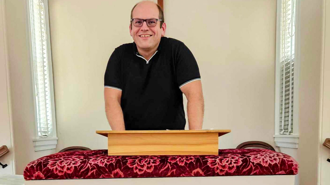 Top view of hand holding teal ribbon on dark background with copy space. Cervical and ovarian cancer, sexual assault, pcos, ptsd, anxiety disorder, agoraphobia and scleroderma awareness concept.