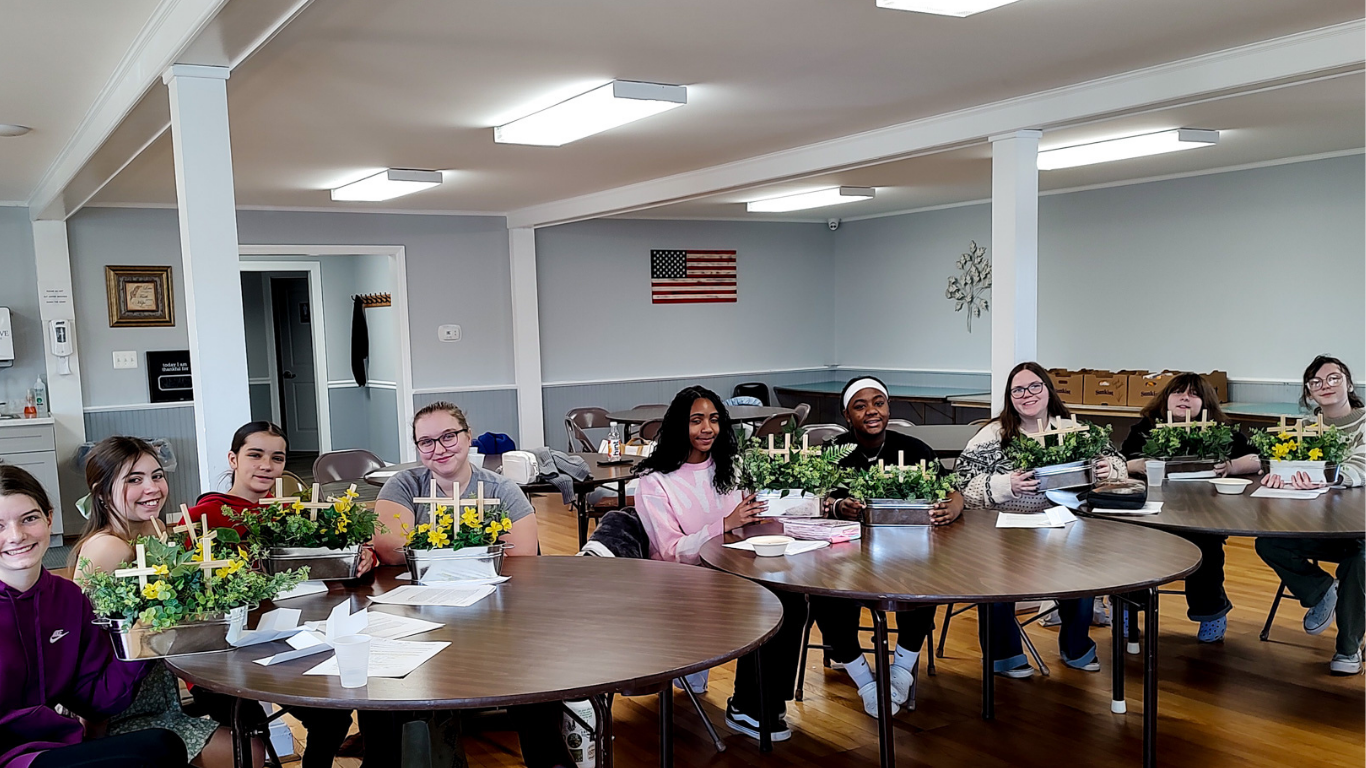 Top view of hand holding teal ribbon on dark background with copy space. Cervical and ovarian cancer, sexual assault, pcos, ptsd, anxiety disorder, agoraphobia and scleroderma awareness concept.